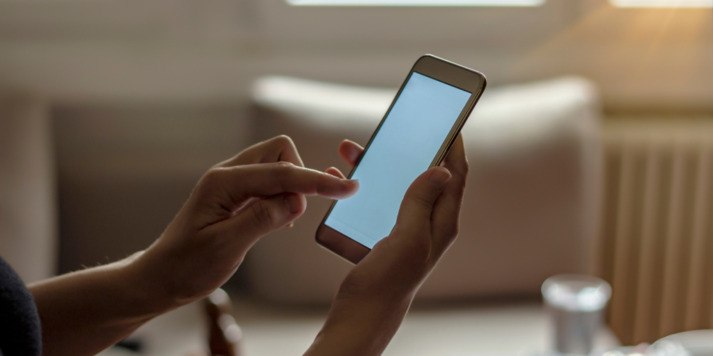 Close-up of hands holding a smartphone with an unresponsive black screen, set against a blue background with blog title text overlay.
